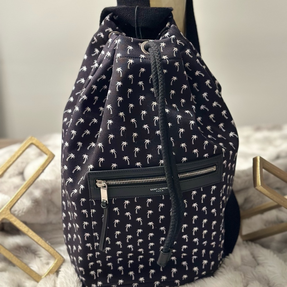 YVES SAINT LAURENT
Black Canvas Palm Tree Print Bucket Backpack Bag